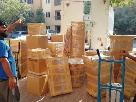 Movers in Dubai unloading furniture at an apartment